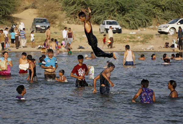 Cư dân địa phương tắm mát ở sông Sabarmati ở ngoại ô thành phố Ahmedabad. Ảnh: Ajit Solanki / AP
