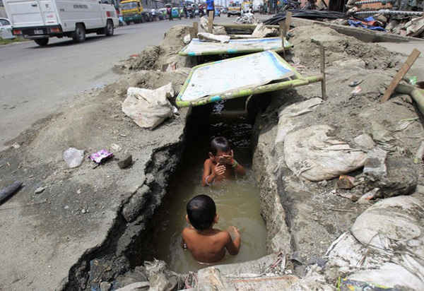 Những đứa bé này đang tắm ở một hệ thống thoát nước lộ thiên tại thành phố Manila, Philippines. (Nguồn ảnh: Internet)