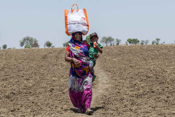 Tại huyện Lalitpur ở Ấn Độ, bà Avadrani, một góa phụ, đã không thể tìm được việc làm trong đợt hạn hán. Bà đi dọc theo dải đất khô cằn với con trai mình, Somath để mong nhận được gói cứu trợ khẩn cấp giúp gia đình bà sống trong một tháng. Hạn hán kéo dài 2 năm ở Ấn Độ đã khiến hơn 300 triệu người bị ảnh hưởng. Ảnh: Tiatemjen Jamir / World Vision