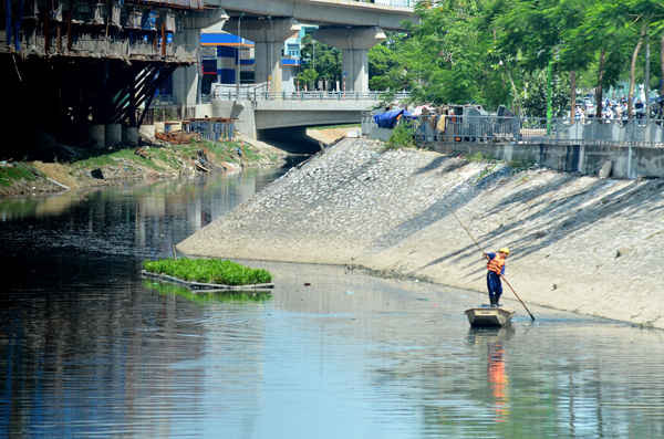 Trong lúc thời tiết nắng nóng đỉnh điểm những người công nhân vệ sinh môi trường phải đẩy thuyền trên những khúc sông để thu gom rác