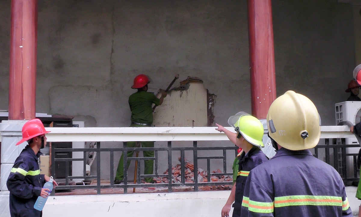 Cảnh sát PCCC & cứu nạn cứu hộ Công an tỉnh Quảng Nam phá tường để tiếp cận đám cháy, tiến hành dập lửa
