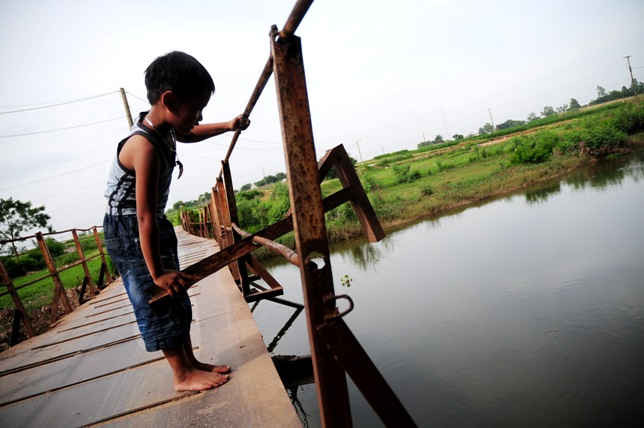 Bé Nguyễn Văn Anh (6 tuổi) hàng ngày vẫn chạy qua chạy lại chiếc cầu. Những thanh lan can cầu đã rụng rời, bé Văn Anh có thể dùng tay để vặn được.