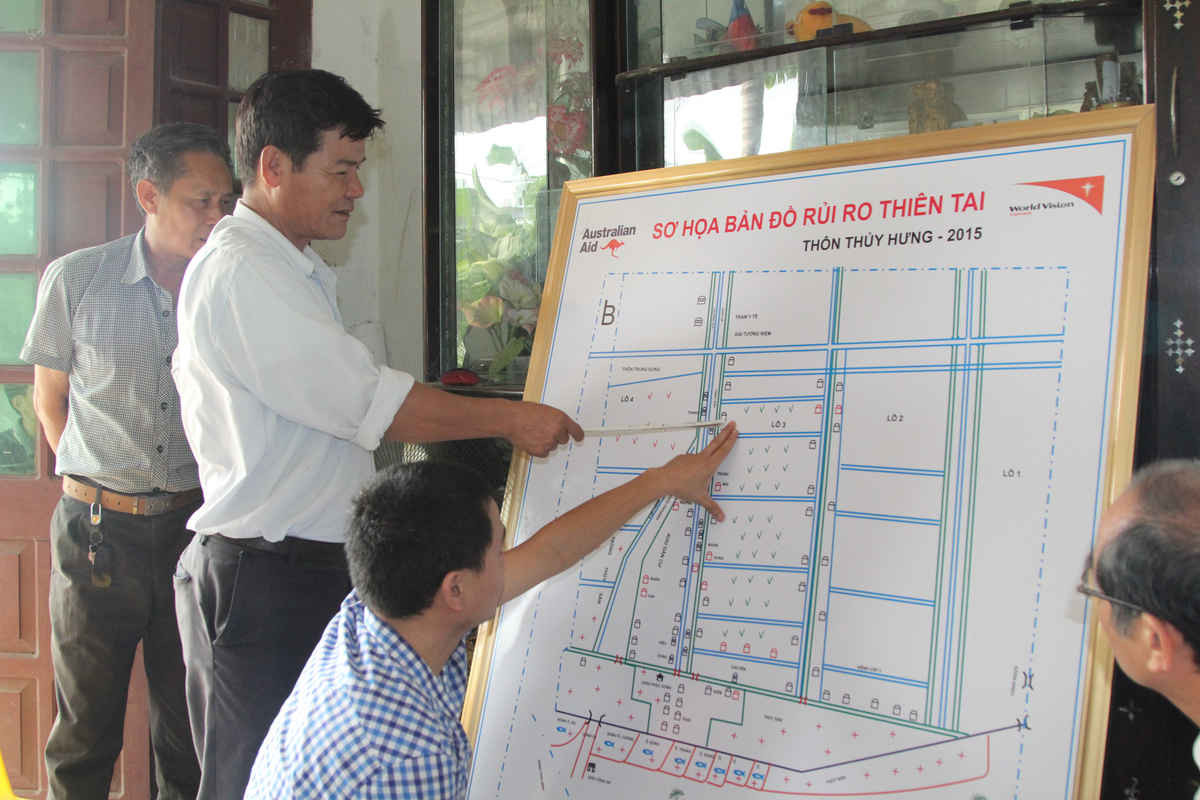 Trưởng thôn Thủy Hưng Nguyễn Thế Chu chỉ dẫn ý nghĩa then chốt của tuyến đường liên xã trong Sơ họa bản đồ rủi ro thiên tai năm 2015 của thôn Thủy Hưng.