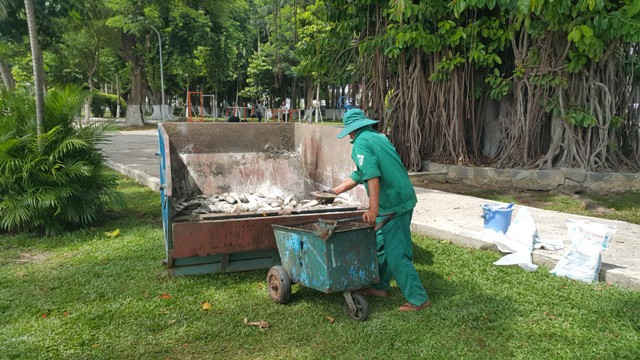 Công nhân Công ty Thoát nước và Xử lý nước thải Đà Nẵng đưa cá chết vào vị trí thu gom, để mang đi tiêu huỷ