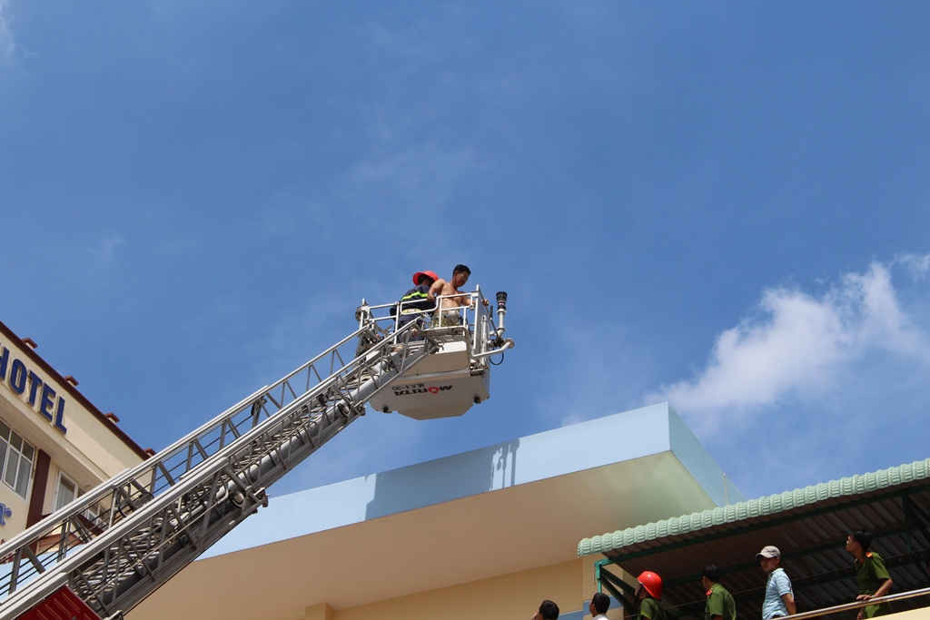 Lực lượng chữa cháy đưa anh Lê Ngọc Mùi, du khách đến từ TP Hồ Chí Minh đang lưu trú ở phòng 509 của Khách sạn Bình Dương bị mắc kẹt trên sân thượng.