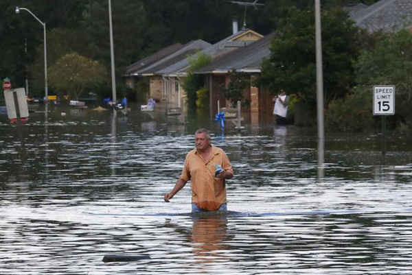Một người đàn ông lội qua dòng nước lũ trên con đường ngập lụt tại giáo xứ Thăng Thiên, Louisiana, Mỹ vào ngày 15/8/2016. Ảnh: REUTERS / Jonathan Bachman