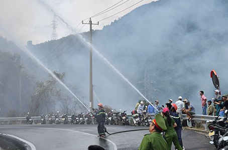 Nhiều lính cứu hỏa kéo ống hàng trăm mét ống xuống phía triền núi, sát đám cháy phía dưới để dập lửa