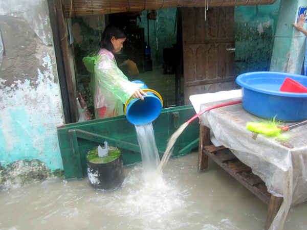 Mưa lớn khiến nước tràn vào trong nhà, nhiều người dân phải tát nước ra ngoài.