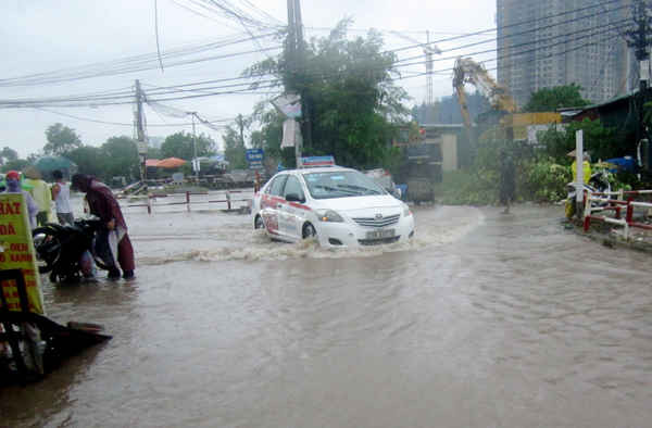 Nước ngập sâu khiến ô tô đi lại gặp khó khăn.
