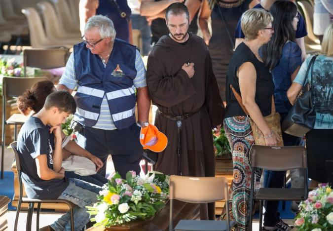 Một tu sĩ bày tỏ sự tôn trọng khi tham dự đám tang của các nạn nhân trong trận động đất tại một trung tâm thể thao ở Ascoli Piceno vào ngày 27/8/2016. Ảnh: REUTERS / Adamo Di Loreto