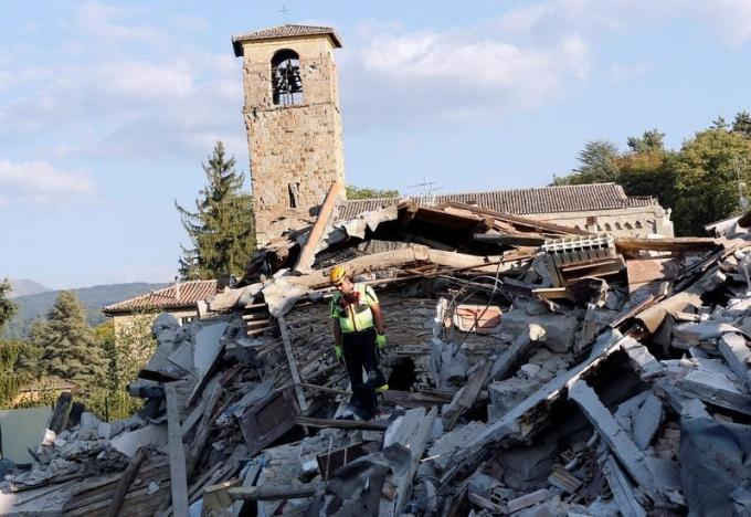 Ngày 27/8/2016, một nhân viên cứu hộ và chú chó nghiệp vụ đang tìm kiếm các manh mối trong đống đổ nát sau trận động đất ở Amatrice, miền trung Italy. Ảnh: REUTERS / Ciro De Luca