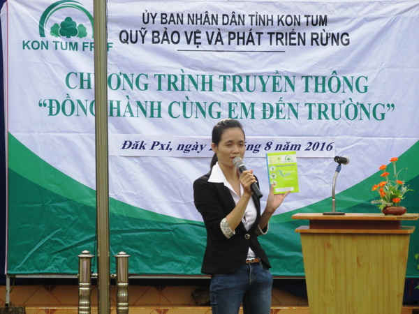 Đại diện Quỹ Bảo vệ và Phát triển rừng Kon Tum truyền tải ý nghĩa những lô gô, biểu ngữ in trên bìa vở đến các em học sinh