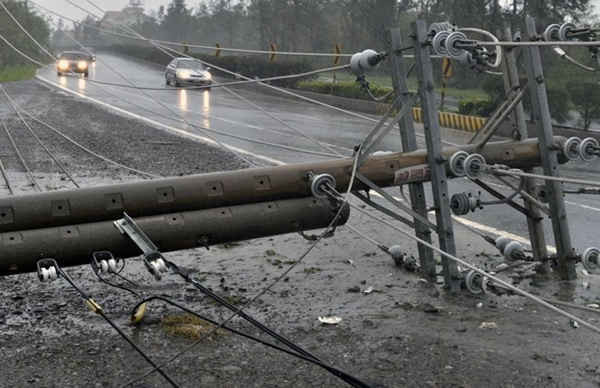 Những chiếc ô tô chạy qua đường dây điện bị đổ, gây chặn đường khi siêu bão Meranti đánh vào quận Pingtung ở miền nam Đài Loan vào ngày 14/9/2016. Ảnh: AFP / SAM YEH