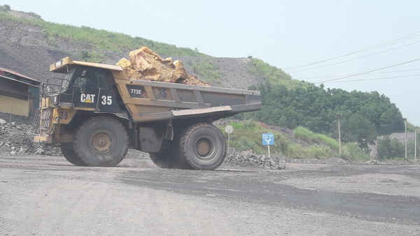 Xe chở đất đá lên bãi thải của Công ty than Khánh Hòa chạy cắt ngang qua đường liên xã Phúc Hà.