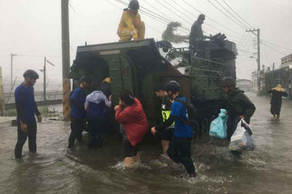 Cư dân Đài Loan bị ảnh hưởng bởi siêu bão Meranti được sơ tán trên một chiếc xe bọc thép quân sự vào ngày 14/9/2016. Ảnh: AFP