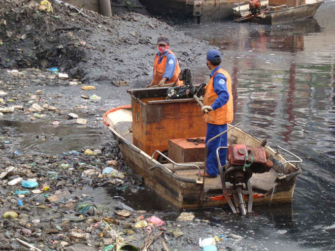 Công nhân vệ sinh môi trường TP.HCM vớt rác trên kênh rạch