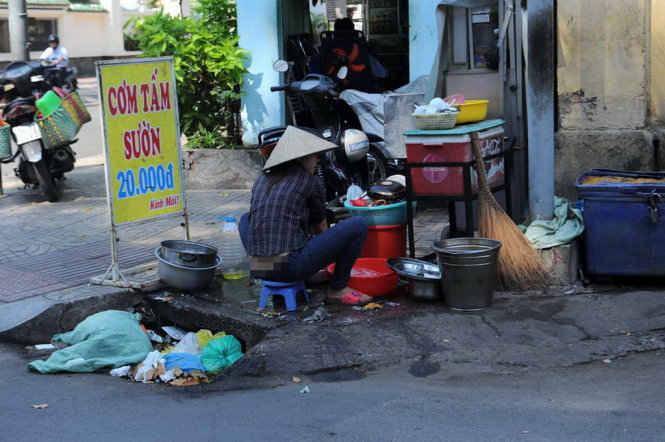 Người bán hàng trên vỉa hè cũng tiện tay xả rác ngay miệng cống trên đường Trần Quang Khải, Quận 1
