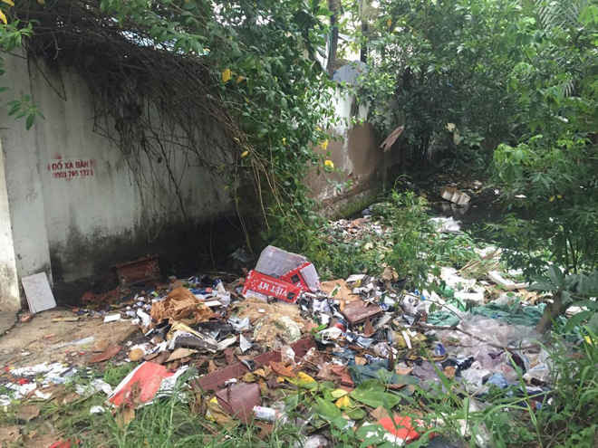 Một con rạch trên địa bàn phường Tân Thuận, Quận 7 bị người dân lấn chiếm xây dựng nhà cửa và đổ rác thải khiến dòng chảy bị thu hẹp