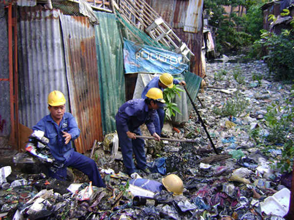 Công nhân vệ sinh môi trường TP.HCM vớt rác trên một con rạch tại quận Bình Thạnh
