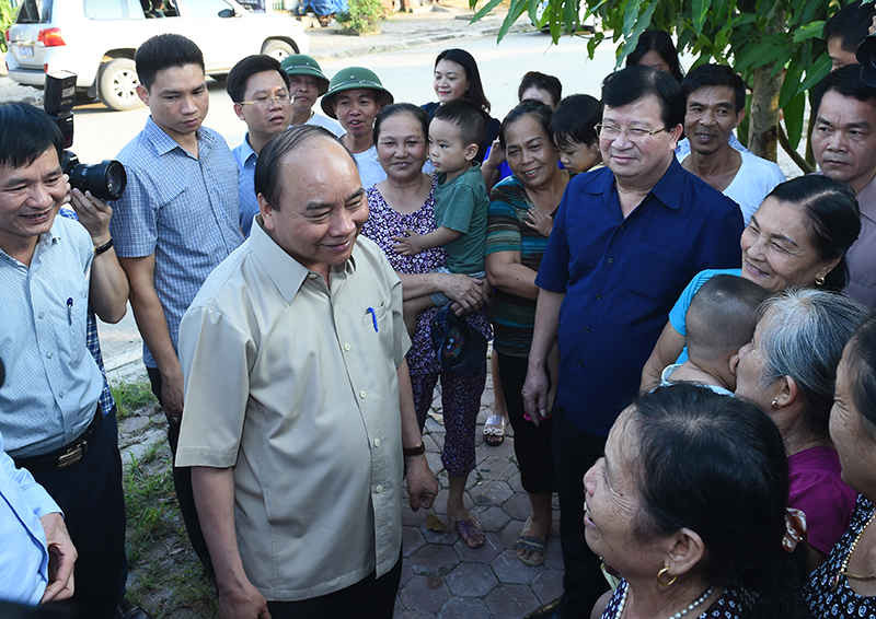 Thủ tướng Nguyễn Xuân Phúc và Phó Thủ tướng Trịnh Đình Dũng trò chuyện với người dân phường Noong Bua. 
