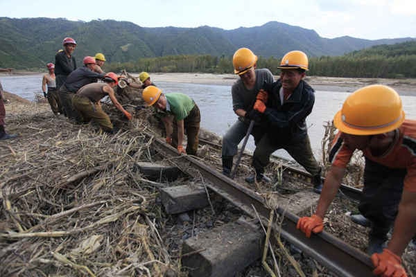 Công nhân sửa chữa đường xe lửa bị hư hỏng do lũ giữa trạm xe lửa Sinjon và Kanphyong ở tỉnh Bắc Hamgyong, Bắc Triều Tiên vào ngày 16/9/2016. Ảnh: AP Photo / Kim Kwang Hyon