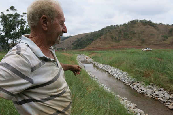 De Souza quan sát những gì Samarco đã làm trên đất của ông, nơi được bảo vệ với lưới và đá. Công ty này đã bị chỉ trích vì làm thay đổi quá trình của một số nhánh sông đã hồi phục. Ảnh: Dom Phillips