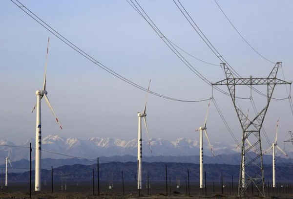 Hình ảnh một tháp điện bên cạnh tuabin gió tại một nhà máy điện gió ở Hami, Khu tự trị Duy Ngô Nhĩ Tân Cương (Tân Cương) của Trung Quốc vào ngày 21/3/2015. Ảnh: REUTERS / Stringer