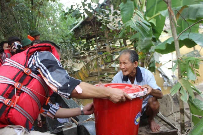Cán bộ y tế hỗ trợ CloraminB cho người dân xử lý nguồn nước sau lũ