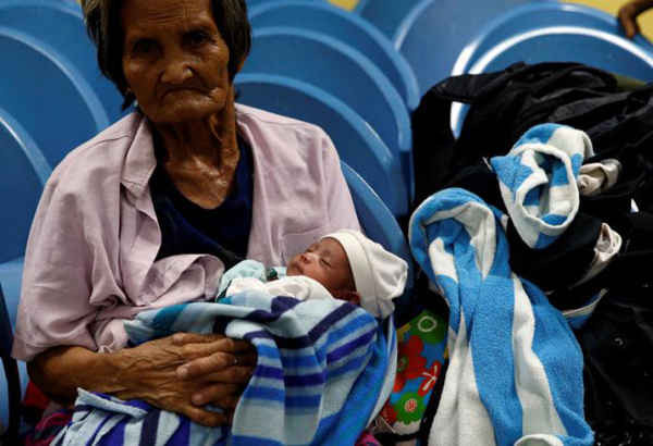 Người phụ nữ bế một em bé tại trung tâm sơ tán các nạn nhân của cơn bão Haima tại San Fernando, la Union, phía bắc Philippines vào ngày 19/10/2016. Ảnh: REUTERS / Erik De Castro