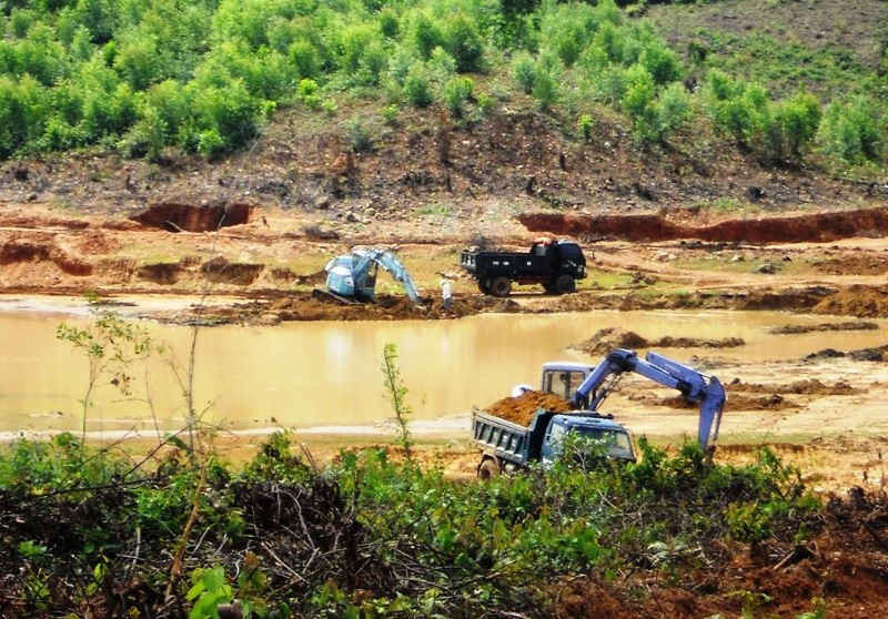 Máy đào đang đào, múc đất trong lòng hồ Đại Sơn đưa lên xe ben chở đi tiêu thụ.