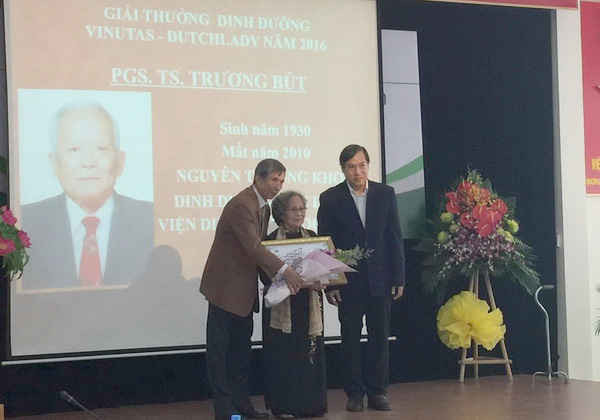 Đại diện FrieslandCampina Việt Nam (bìa phải) trao tặng giải thưởng dinh dưỡng VINUTAS – DUTCH LADY 2016 cho phu nhân cố PGS – BS Trương Bút