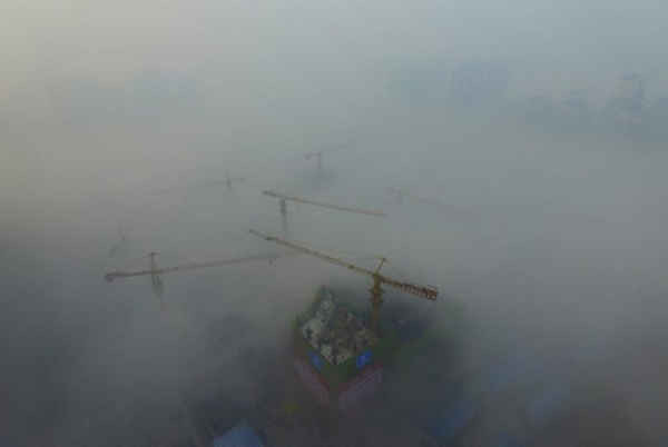 Hình ảnh những chiếc cần cẩu trên một khu vực xây dựng trong sương mù dày đặc ở Tây An, tỉnh Thiểm Tây, Trung Quốc vào ngày 29/11/2015. Ảnh: REUTERS / Stringer
