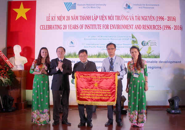 Phó Giám đốc Phụ trách Đại học Quốc gia TP.HCM Huỳnh Thành Đạt (thứ 2 từ trái sang) trao Cờ thi đua của Bộ Giáo dục và Đào tạo cho Viện Môi trường và Tài nguyên