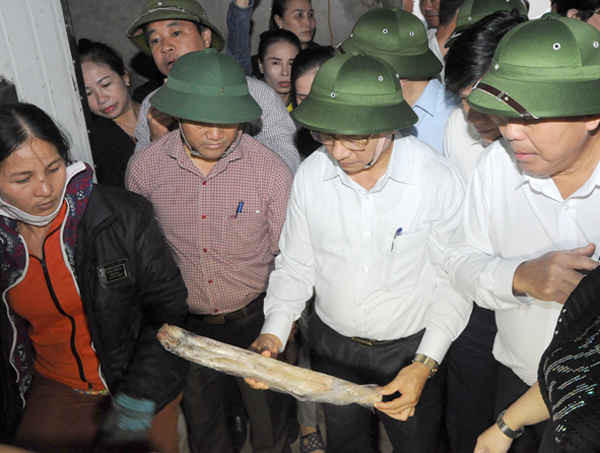 Bí thư Tỉnh ủy Hà Tĩnh cầm mẫu cá của tiểu thương trong kho đông lạnh để báo cáo tình hình với Phó Thủ tướng