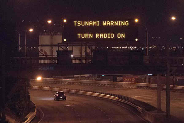 Cảnh báo sóng thần được phát trên bảng thông báo trên đường State Highway 1 tại Wellington sau trận động đất đêm 13/11 xảy ra ở New Zealand. Ảnh: Marty Melville / AFP / Getty Images
