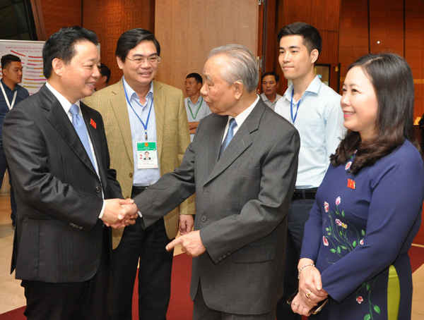 Bộ trưởng Trần Hồng Hà trao đổi với nguyên Phó Thủ tướng Nguyễn Mạnh Cầm bên hành lang Quốc hội sáng 15/11. Ảnh Việt Hùng