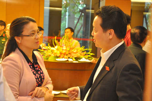 Bộ trưởng Trần Hồng Hà trao đổi với Đại biểu Quốc hội bên hành lang Quốc hội chiều 16/11. Ảnh: Việt Hùng