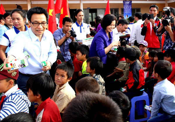 Phó Thủ tướng Vũ Đức Đam và bà Bùi Thị Hương – Giám đốc Điều hành Vinamilk đang trao sữa học đường của Vinamilk cho học sinh trường tiểu học dân tộc khó khăn nhất của tỉnh Đắk Nông