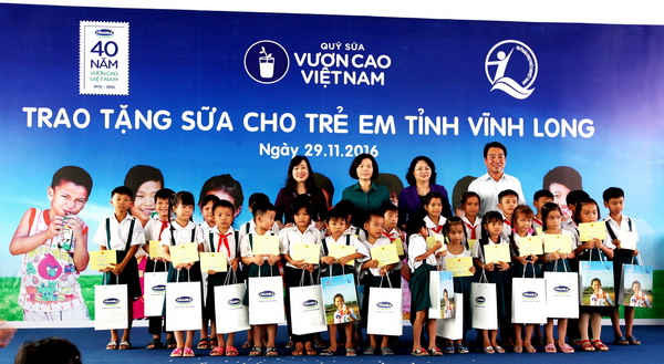 Phó Chủ tịch nước Đặng Thị Ngọc Thịnh và các đại biểu trao tặng sữa cho các em học sinh Trường tiểu học Hoà Bình A trong chương trình Quỹ sữa Vươn cao Việt Nam tại Vĩnh Long