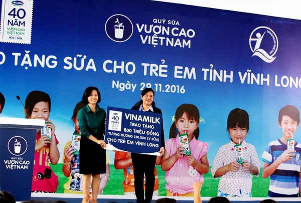 Bà Bùi Thị Hương – Giám đốc Điều hành Vinamilk trao tặng bảng tượng trưng 130.000 ly sữa với tổng trị giá 800 triệu đồng của Quỹ sữa Vươn cao Việt Nam cho học sinh nghèo Vĩnh Long 