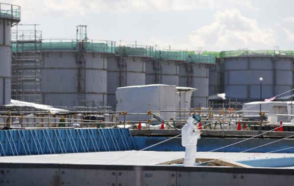 Ngày 10/2/2016, một công nhân mặc quần áo bảo hộ và đeo khẩu trang đang ghi chép ở phía trước bể chứa nước phóng xạ tại nhà máy điện hạt nhân Fukushima Daiichi bị sóng thần tàn phá ở thị trấn Okuma, tỉnh Fukushima, Nhật Bản. Ảnh: REUTERS / Toru Hanai
