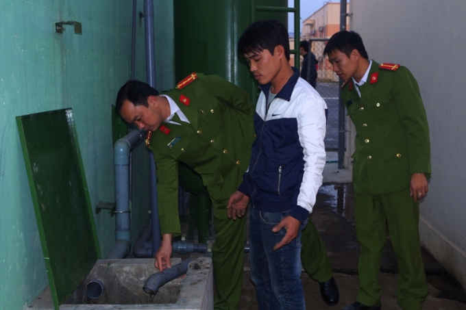 Trịnh Hùng Mạnh (áo khoác xanh trắng) nhân viên Công ty TNHH JY Plastic bị bắt quả tang khi đang xả nước thải chưa qua xử lý ra môi trường. Ảnh Công an Hà Nam.