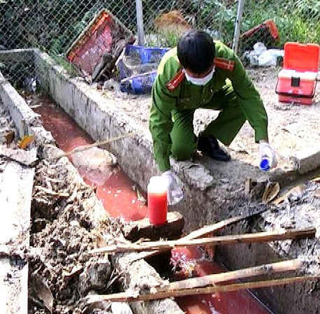 Cán bộ Phòng Cảnh sát Phòng chống Tội phạm về Môi trường- Công an tỉnh Hậu Giang đang  lấy mẫu nước thải ở một lò giết mổ trên địa bàn tỉnh Hậu Giang.