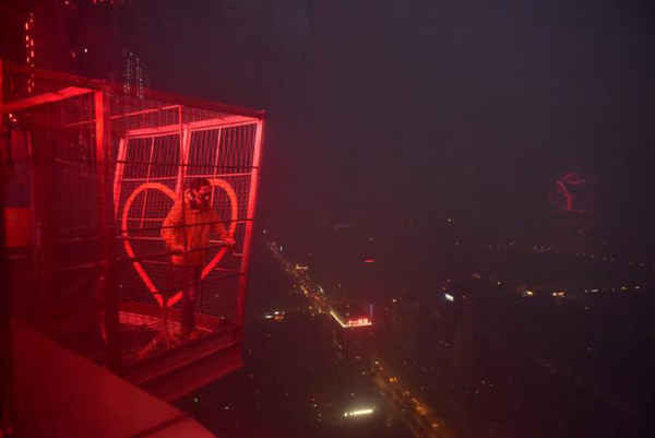 Một người đàn ông đứng trên đỉnh tòa tháp truyền hình trong bầu không khí bị sương mù bao phủ ở Thành Đô, tỉnh Tứ Xuyên vào ngày 20/12/2016. Ảnh: REUTERS / Stringer