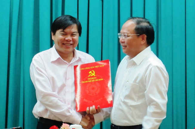 Phó Bí thư Thường trực Thành ủy Tất Thành Cang trao quyết định cho ông Tăng Hữu Phong (bên trái). 