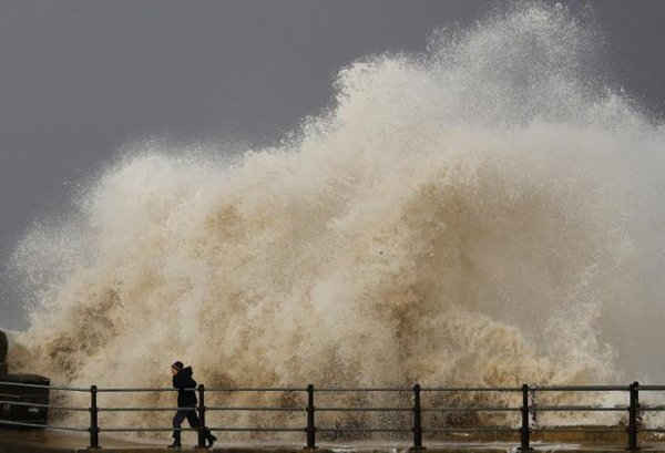 Làn sóng đập liên hồi vào một người khi người này đang đi bộ dọc theo bờ biển ở New Brighton, phía Bắc nước Anh vào ngày 16/11/2016. Ảnh: REUTERS / Phil Noble