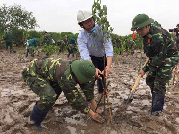 Thứ trưởng Bộ TN&MT Võ Tuấn Nhân cùng Bộ đội biên phòng buộc cố định cây sau khi trồng