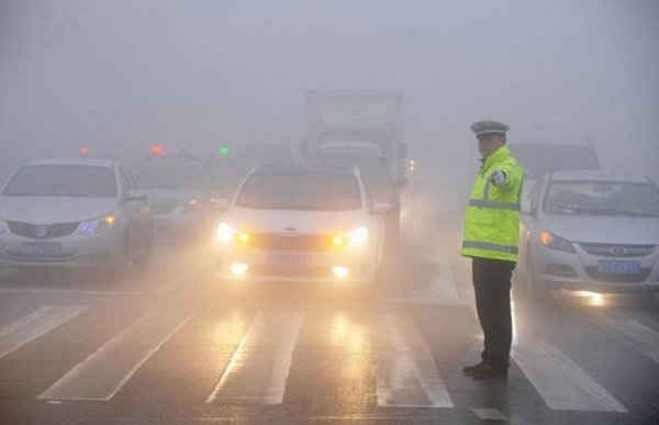 Một cảnh sát giao thông làm việc trong điều kiện sương mù dày đặc trong một ngày ô nhiễm ở Bozhou, tỉnh An Huy, Trung Quốc, ngày 5/2/2017. Ảnh: REUTERS