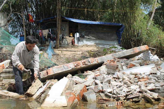 Ông Dương Thành Điền gom góp gạch cũ từ đống đổ nát để giảm bớt chi phí mua vật liệu xây dựng khi xây nhà mới.