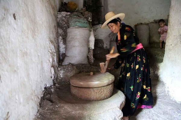 Người phụ nữ sử dụng máy xay đá để làm bột mì trong ngôi nhà của bà ở vùng núi huyện Jafariya, tỉnh Raymah, phía Tây Yemen vào ngày 21/5/2016. Ảnh: REUTERS / Abduljabbar Zeyad